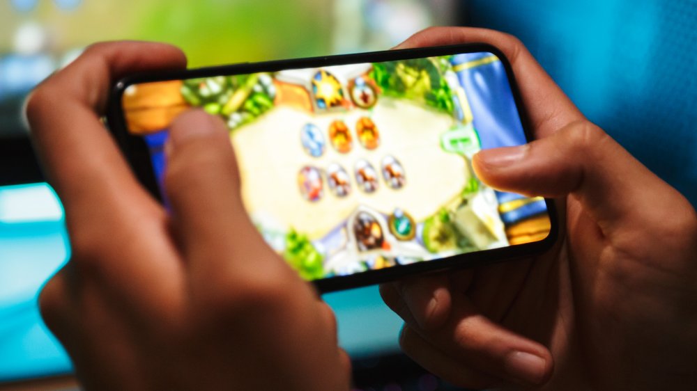 Hands playing mobile game