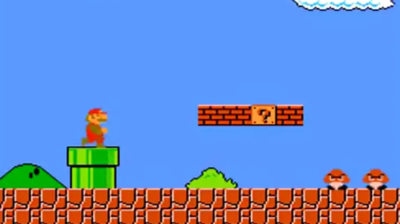 Mario exiting green pipe to face Goombas