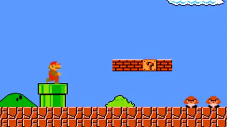 Mario exiting green pipe to face Goombas