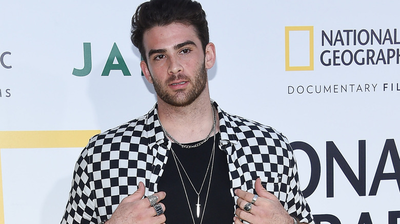 Hasan Piker at a red carpet event in a checkered shirt