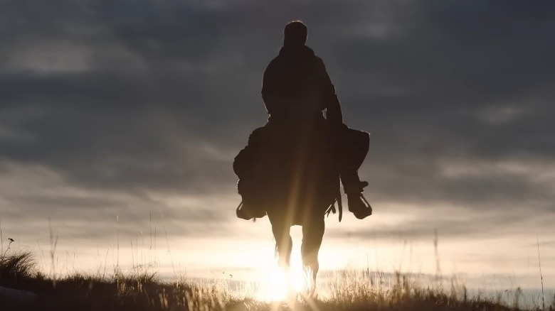 Silhouette of Joel and Ellie on horseback