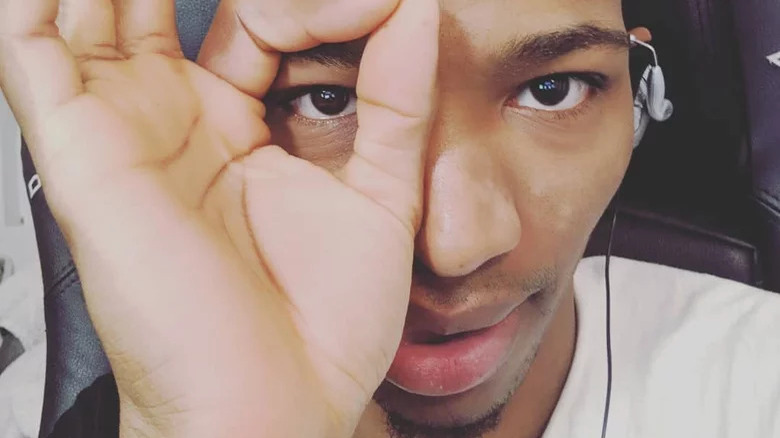 Etika holding fingers over eye