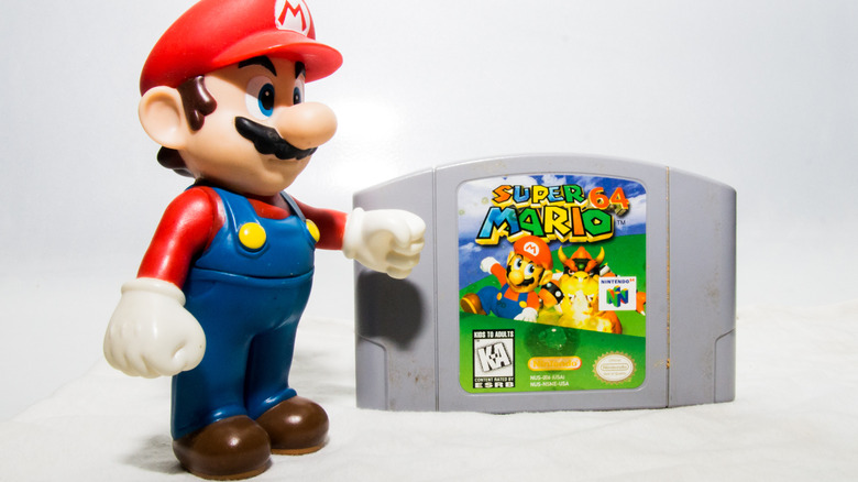 Mario standing with Nintendo 64 game
