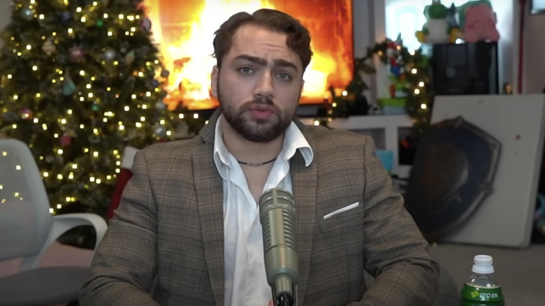 Mizkif by Christmas tree and fireplace