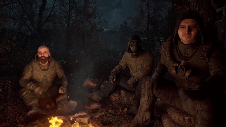 Three men sitting around campfire