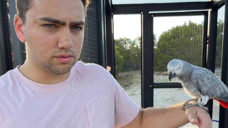 Mizkif holding an African Gray Parrot