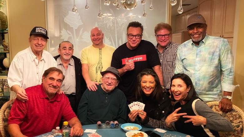 Kelly Hu holding up a straight flush at poker game