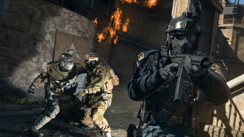 Soldier aiming rifle while two others fight behind him