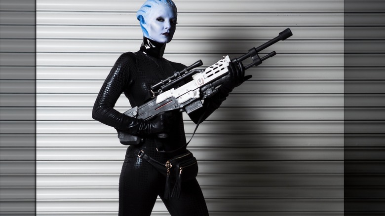 Liara holds gun in alley