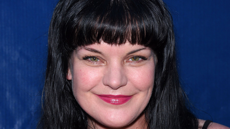 Pauley Perrette smiling and posing at an event