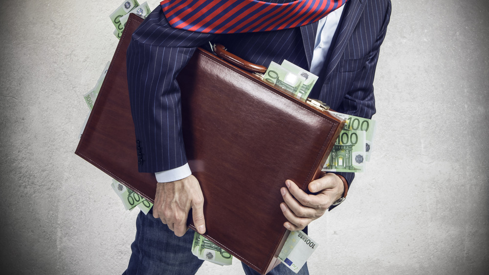 man running with suitcase full of money