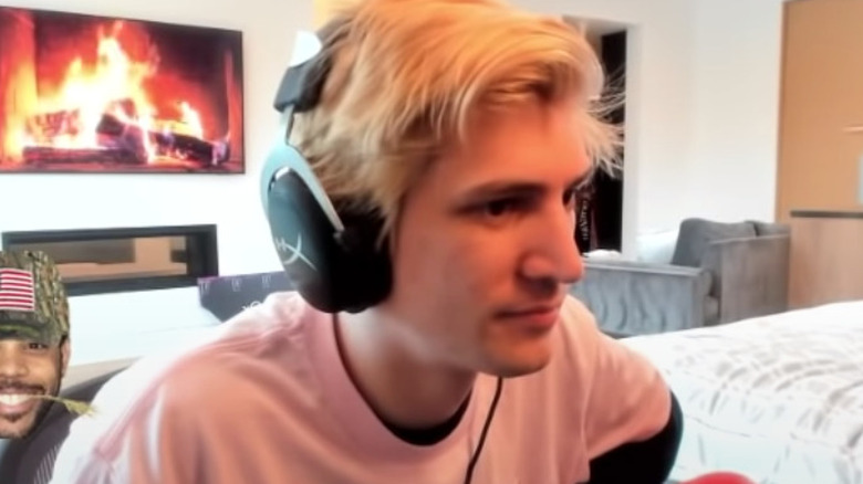 xQc with fire log in background 