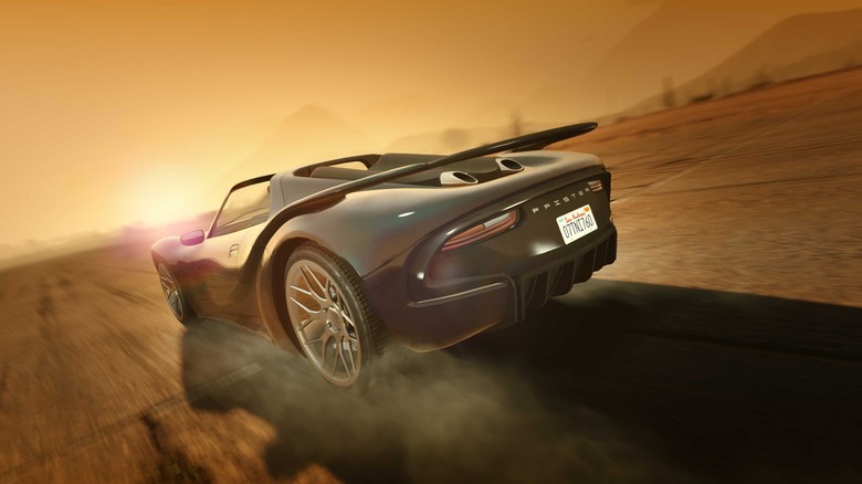 A screenshot from GTA Online showing a gray Pfister vehicle driving along a road. 