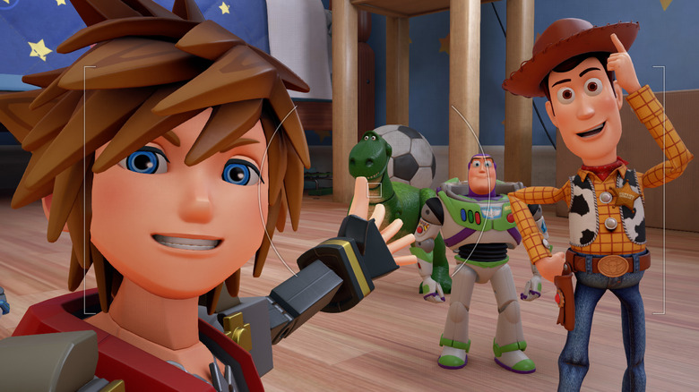 Sora posing for photo with Woody and Buzz