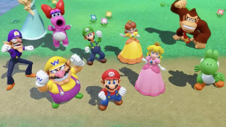 Birdo looking up and cheering with other characters