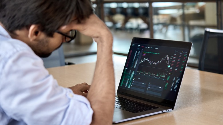Person watching stock market on laptop