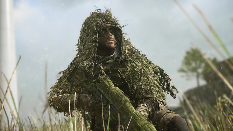 Sniper in tall grass wearing ghillie suit