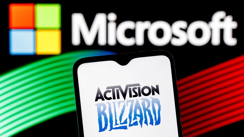 Phone with Activision Blizzard logo in front of Microsoft logo