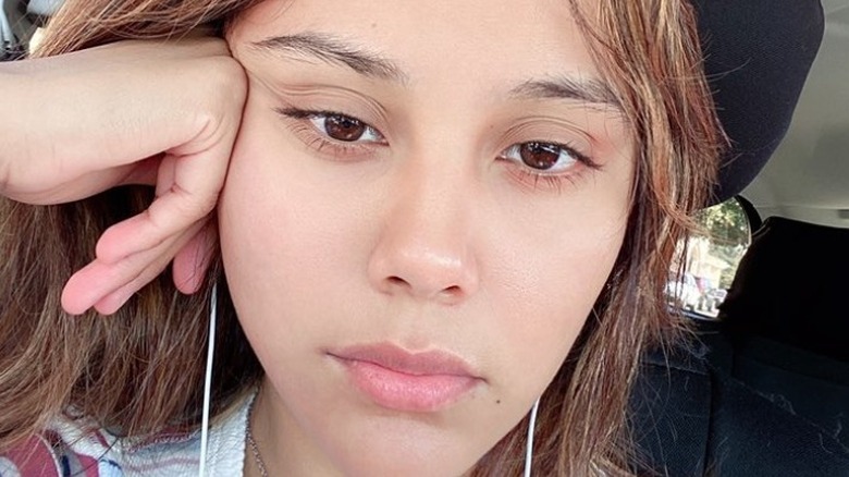 Neekolul sitting in her car without makeup