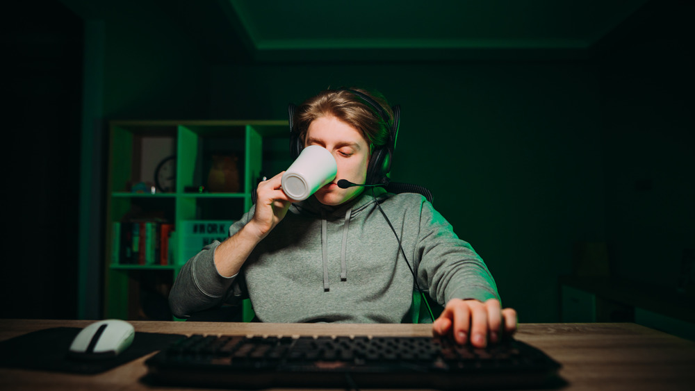 Gamer drinking coffee while playing.