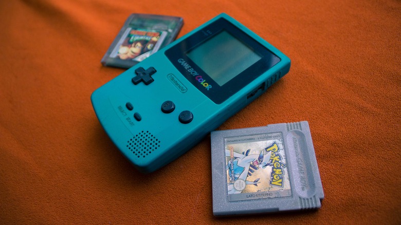A Game Boy Color with copies of "Pokémon Silver" and "Donkey Kong Country"