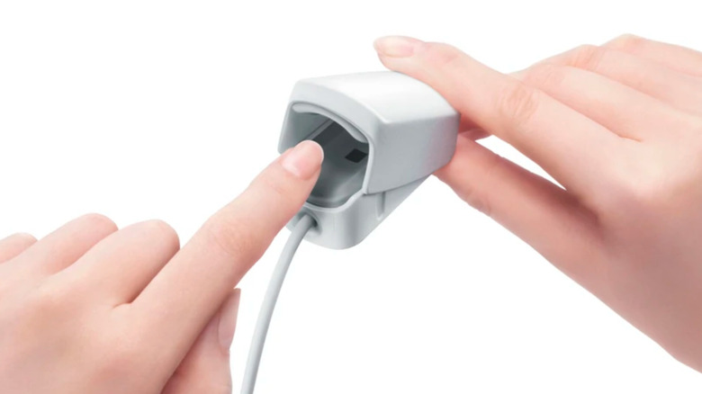 Render of individual inserting finger into the Wii Vitality Sensor
