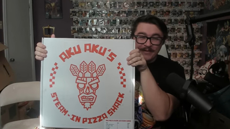 Canadian Guy Eh holding up Aku Aku pizza box
