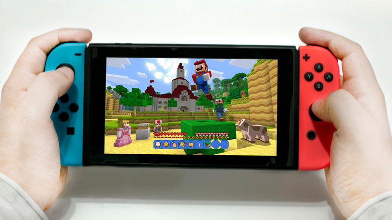 A kid holds a Nintendo Switch with Minecraft on the screen